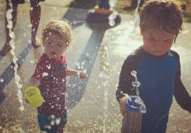 Kids playing in a water fountain.