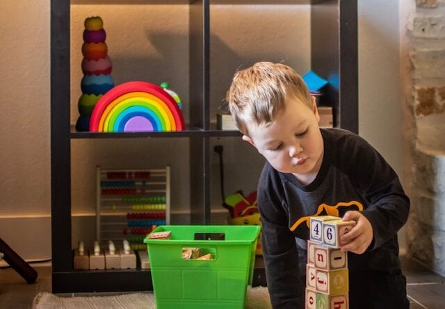 A little boy loves to play in his Montessori Home Learning Area